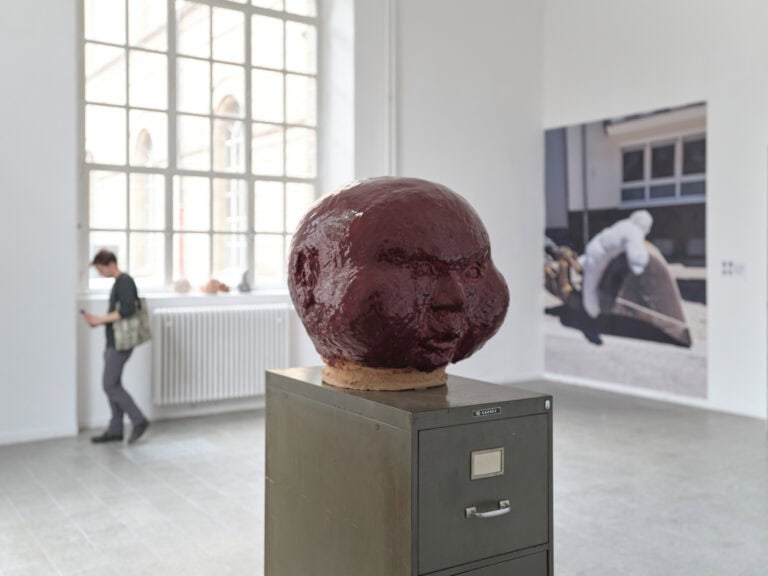 Foto: Nahaufnahme einer Objektes. Im Hintergrund ist ein Raum mit weißen, Wänden, grauem Boden, einem Fenster und weiteren Objekten zu erkennen.