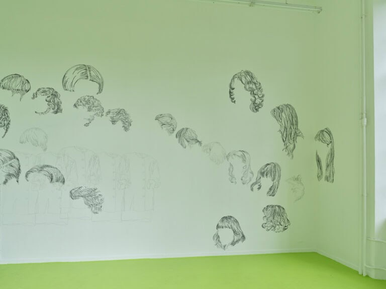 Foto: Ansicht eines Raumes mit weißen Wänden und leichtend grünem Boden. Die Wand ist Stellenweile mit schwarzer Farbe bemalt.