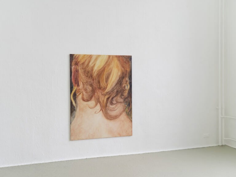 Foto: Ansicht eines Raumes mit weißen Wänden und grauem Boden. An der Wand hängt eine großformatige Malerei.