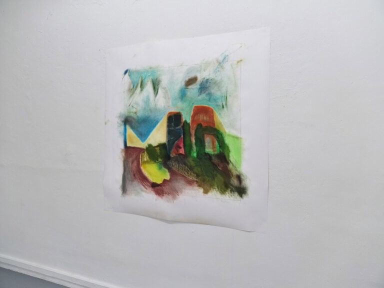 Foto: Nahaufnahme einer bunten Arbeit auf Papier vor weißer Wand.